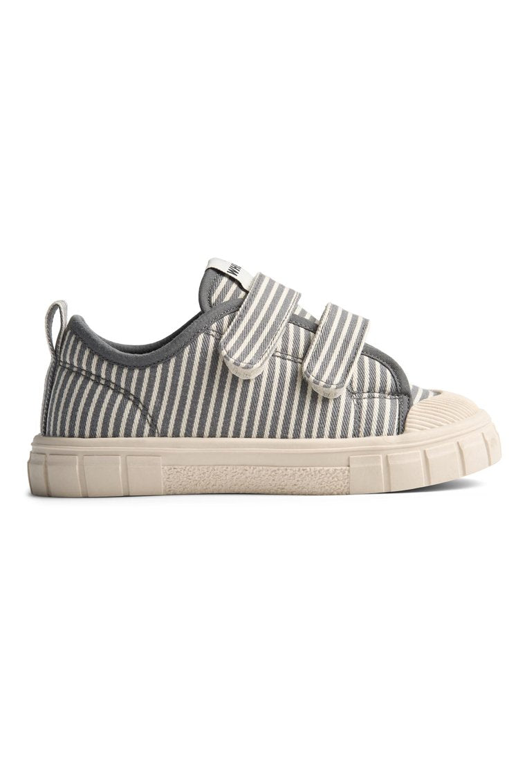 Gestreifte Canvas-Sneaker mit Klettverschlüssen, grau-weiße Streifen, Gummisohle, runde Zehenpartie und strukturierte Details an der Sohle.