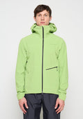 Mann steht und trägt eine hellgrüne Kapuzenjacke mit Frontreißverschluss und schwarzer Reißverschlusstasche, kombiniert mit dunkler Hose, neutraler Hintergrund.