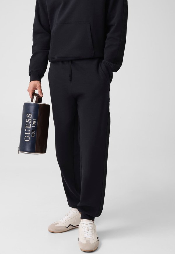Guess JOGGINGHOSE MIT SEITLICHEM LOGO - Tracksuit bottoms - schwarz