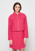 Gekürzte rosa Tweedjacke mit langen Ärmeln, zwei Fronttaschen und einem Reißverschluss sowie einem passenden Rock mit ähnlicher Struktur.