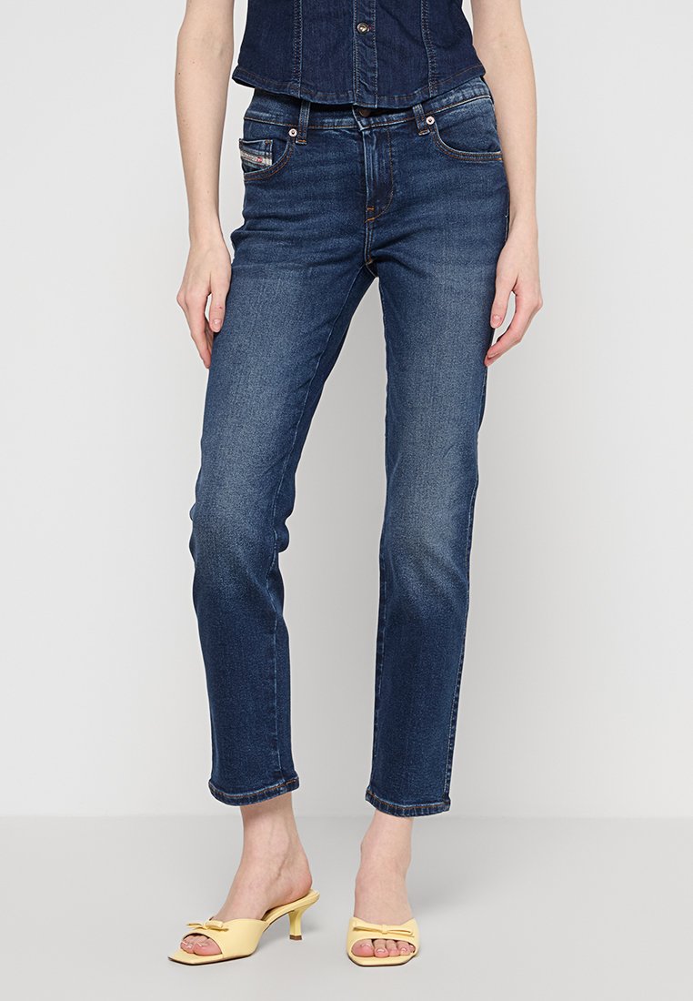 Dunkelblaue Jeans aus Denim mit geradem Schnitt, ausgestattet mit Fronttaschen, einem Reißverschluss und dezenten Nähakzenten. Glatte Textur, leicht ausgebleicht.