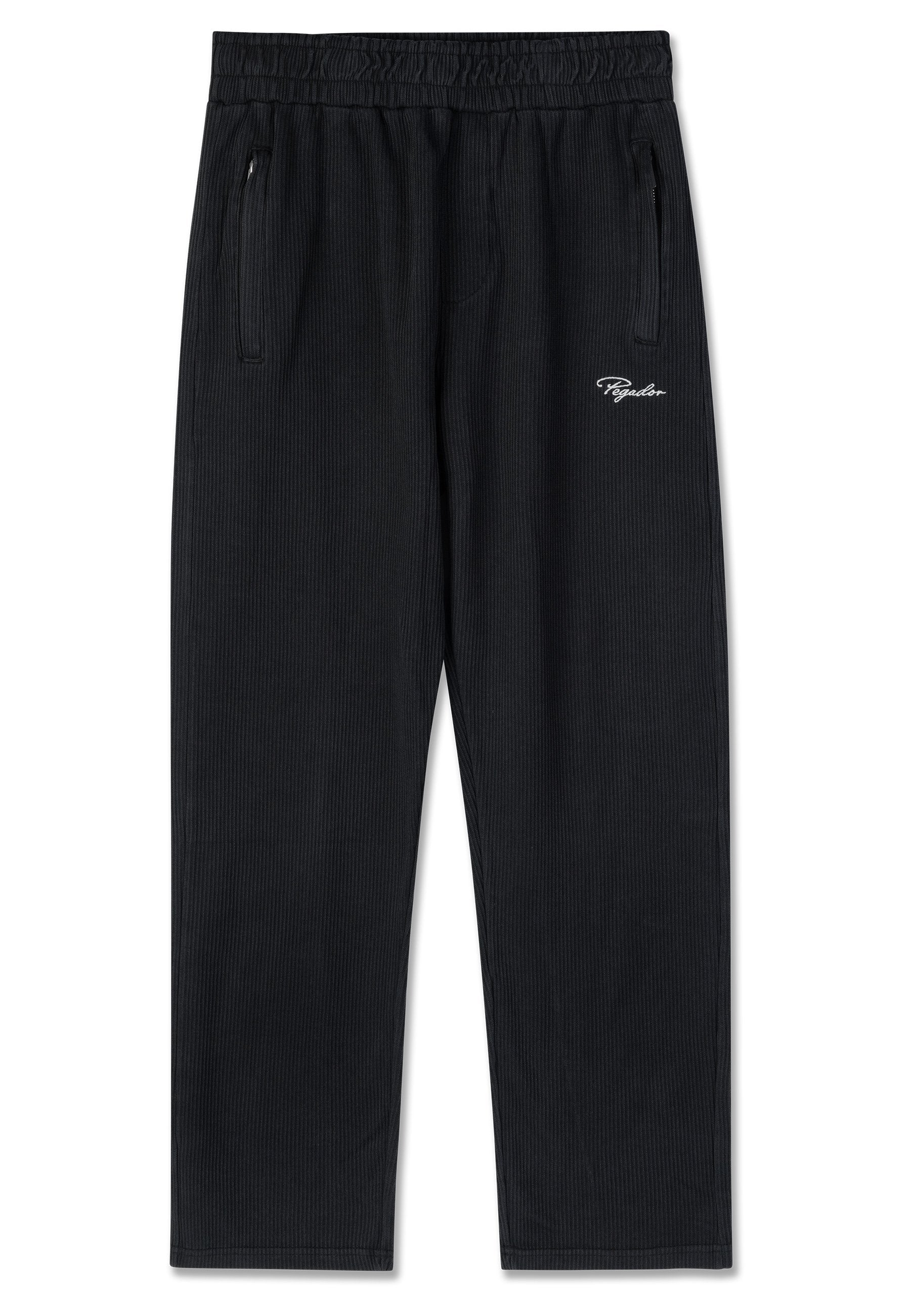Schwarze gerippte Lounge-Hosen mit elastischem Bund, zwei Reißverschlusstaschen und einem weißen, gestickten Logo an der Seite.