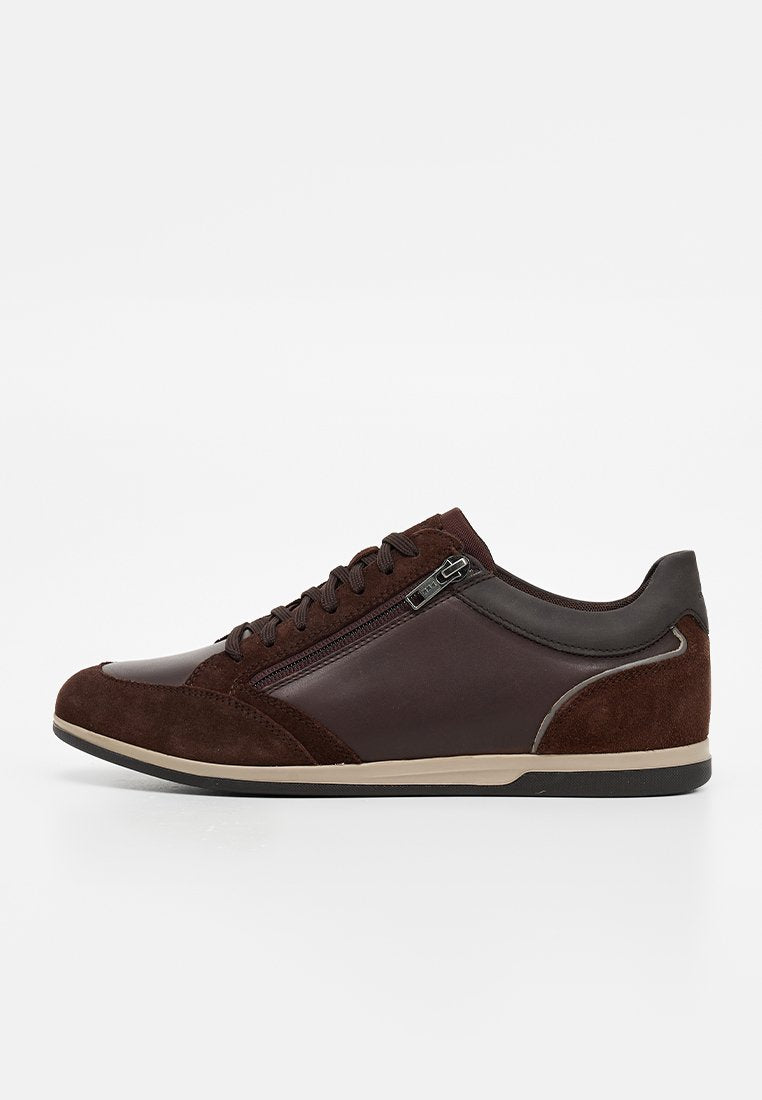 Dunkelbrauner Sneaker mit niedrigem Schaft, vorne mit Schnürung und seitlichem Reißverschluss, kombiniert aus Leder- und Wildlederpaneelen, beige Zwischensohle und schwarze Außensohle.