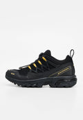 Schwarz-goldener Salomon Trailrunning-Schuh mit robustem Profil, Zuglasche an der Ferse und Schnellverschluss-System.