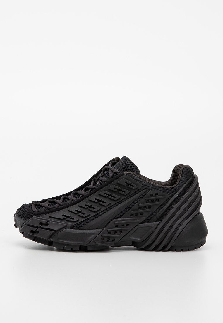 Schwarzer Sportschuh mit einem strukturierten Mesh-Obermaterial, Gummisohle und auffälligen Seitenverzierungen mit geometrischen Mustern und Rillen.
