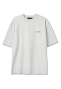 Schlichtes weißes übergroßes T-Shirt mit kurzen Ärmeln, "PEGADOR" Schriftzug-Logo auf der linken Brust und Branding innen am Kragen.