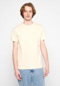 Hellbeige T-Shirt mit kurzen Ärmeln aus Baumwolle. Einfacher runder Ausschnitt, lockere Passform, mit einem kleinen erhabenen Logo auf der Brust.