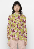 Langärmlige Bluse aus leichtem, transparentem Stoff. Mit Blumendesign und grünen sowie lila Akzenten auf einem rosafarbenen Hintergrund. Klassisches Kragen-Design.