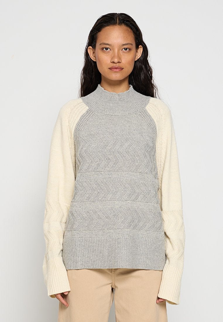 Grau und cremefarbenes Sweatshirt mit hohem Kragen, strukturiertem Zickzackmuster auf dem Oberteil und gerippten Bündchen mit Zopfstrickdetails an den Ärmeln.