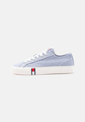 Hellblauer Canvas-Sneaker mit niedrigem Schaft, weißen Schnürsenkeln und Sohle, mit einem kleinen roten, weißen und blauen Tommy Jeans Logo an der Seite.