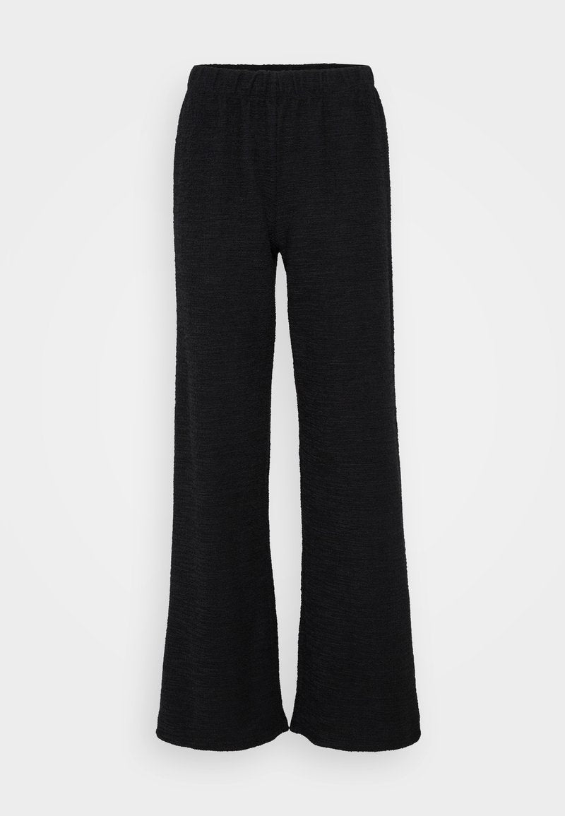 Schwarze weit geschnittene Hose aus strukturiertem Stoff, mit einem elastischen Bund und einer lockeren Passform, die für Komfort und Bewegungsfreiheit sorgt.