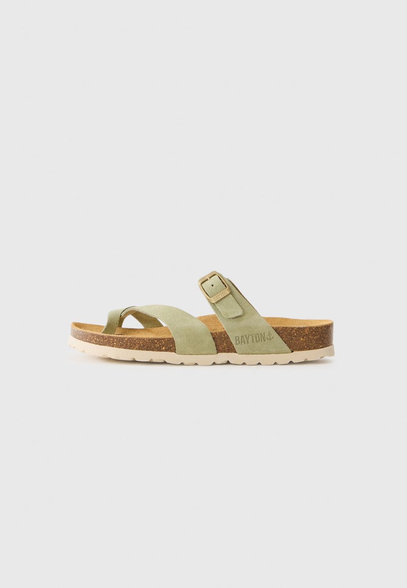 Grüne Wildleder-Sandalen mit Korkfußbett und gummierter weißer Sohle. Sie verfügen über einen Riemen mit einer Metallschnalle zur Anpassung und ein minimalistisches Design.