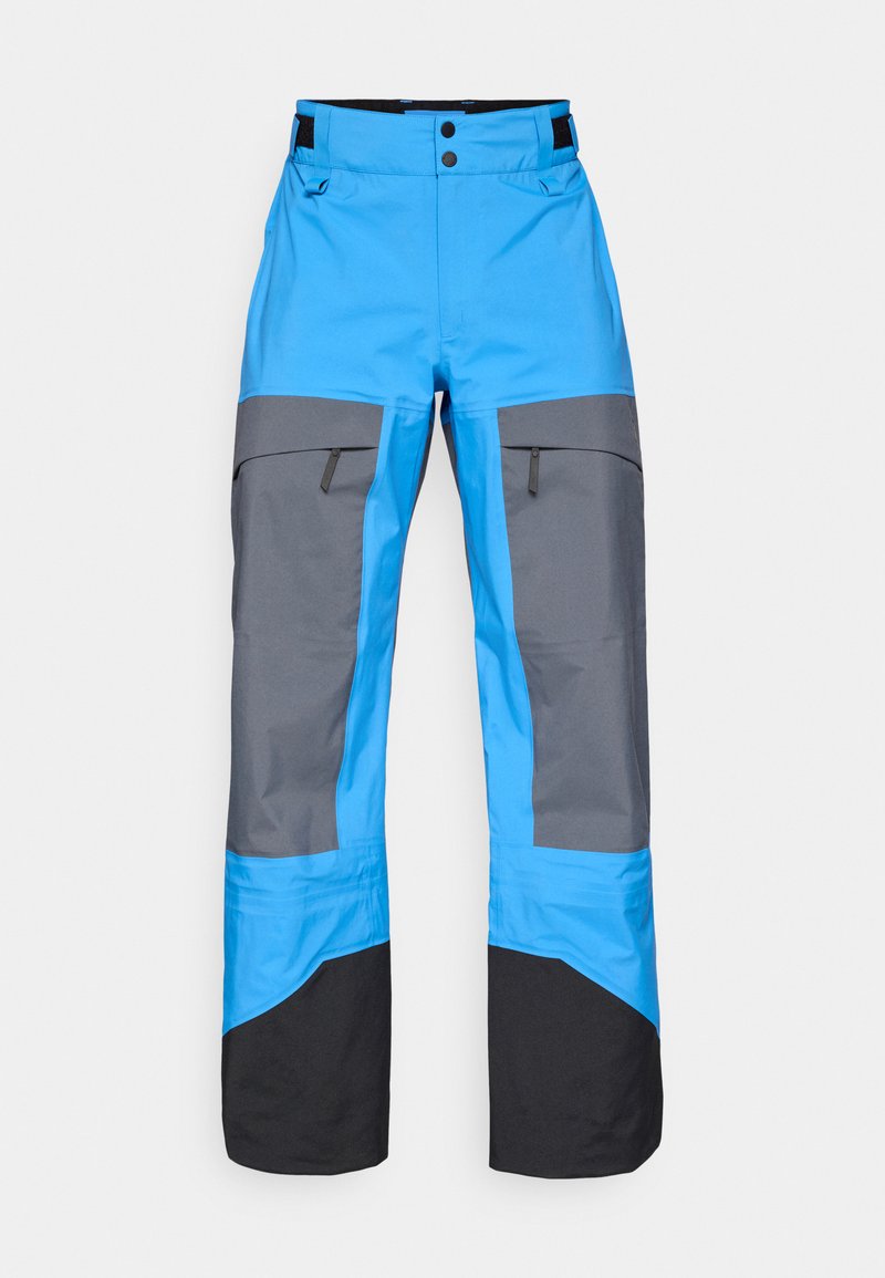 Blaue und graue wasserdichte Hosen mit geradem Schnitt, ausgestattet mit Reißverschlusstaschen, kontrastierenden Farben und einem schwarzen unteren Saum.