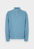 Hellblauer Pullover mit halbhohem Reißverschluss am Kragen, langen Ärmeln und gerippten Bündchen. Verfügt über ein dezentes Logo auf der Brust. Glatte Textur.