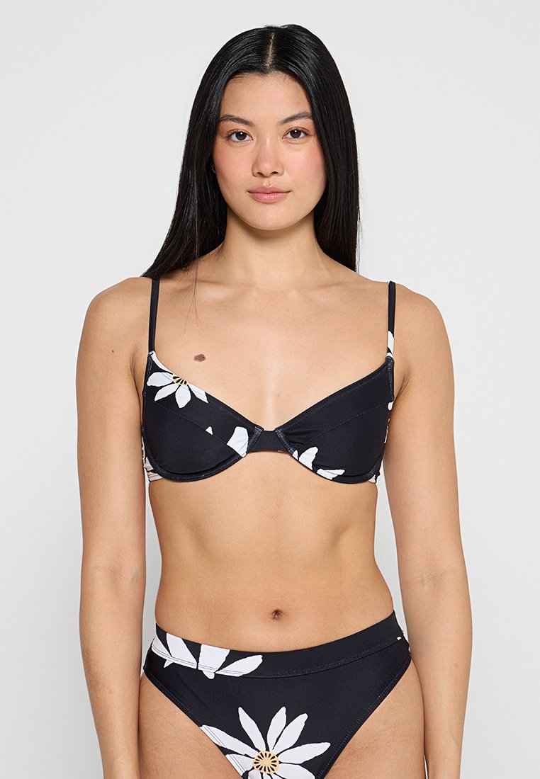 Schwarzes Bikini mit weißem Blumenmuster, ausgestattet mit verstellbaren dünnen Trägern, in klassischer Dreiecksform und mit einfarbigem Höschen.