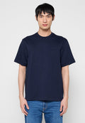 Marineblaues Baumwoll-T-Shirt mit Rundhalsausschnitt, kurzen Ärmeln und einem dezenten Logo. Kombiniert mit blauen Jeans aus Denim. Glatte Textur.