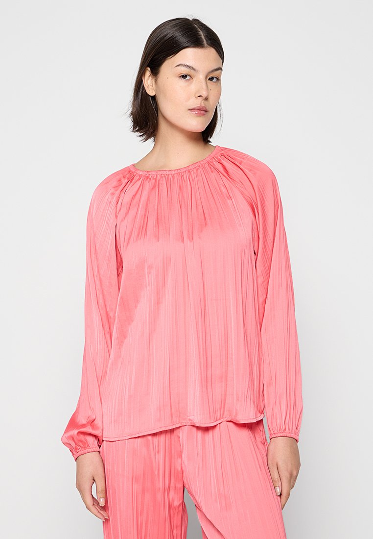 Langärmliges Oberteil in leuchtendem Pink, aus plissiertem Stoff. Verfügt über einen runden Halsausschnitt und elastische Bündchen, die eine lässige Passform schaffen.