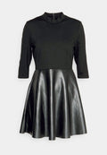 Schwarzes Kleid mit einem figurbetonten Langarmoberteil aus einem weichen Material und einem ausgestellten Rock aus schimmerndem Lederimitat. Das Kleid hat einen hohen Kragen und einen Reißverschluss auf der Rückseite.