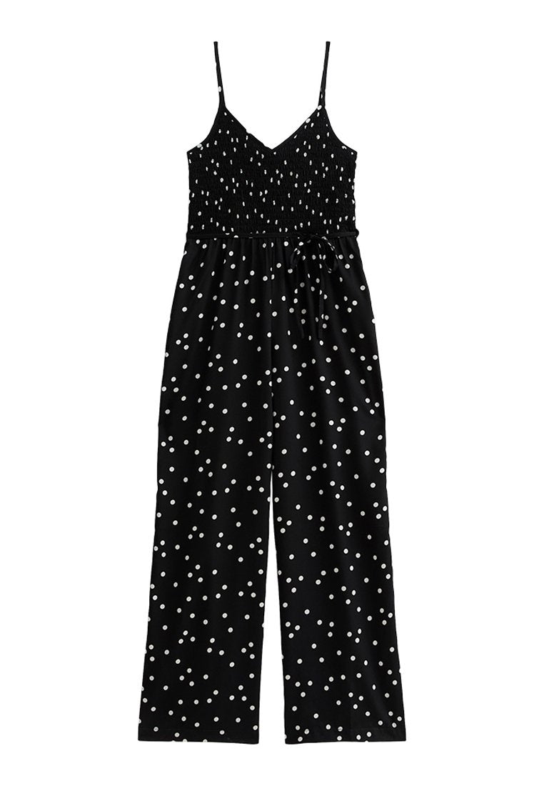 Schwarzer Jumpsuit mit weißen Punkten, gerafftem Oberteil, dünnen Trägern und weitem Bein-Design. Verfügt über einen Taillengürtel zur Anpassung.