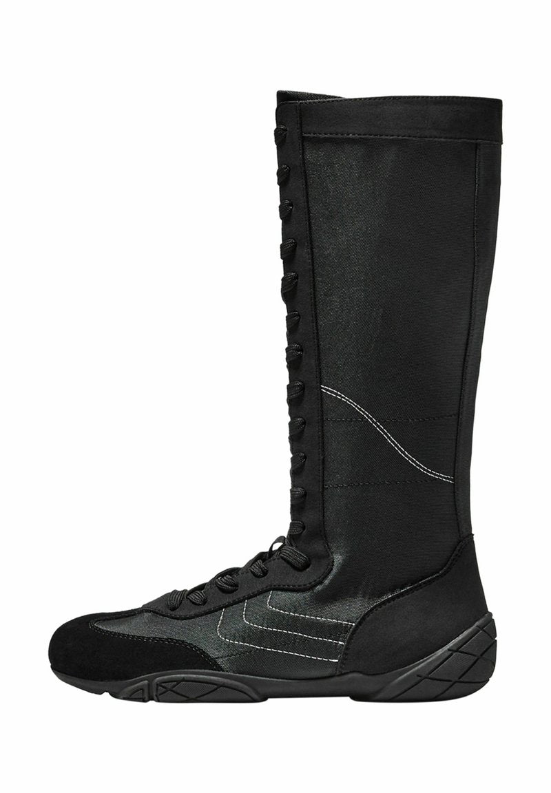 Schwarze High-Top-Stiefel aus glattem Stoff mit Wildlederakzenten, die eine geschnürte Vorderseite und eine strukturierte Sohle mit geometrischem Muster aufweisen.