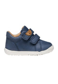 Navyblauer Lederschuh für Kleinkinder mit doppelten Klettverschlüssen und weißer Gummisohle, mit einem kleinen braunen Lederfleck am Riemen.