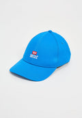 Blaues Baumwollcap mit gebogenem Schild, das ein weißes "DIESEL"-Logo und rote Akzente aufweist. Glatte Textur mit sichtbaren Nähdetails an den Seiten.