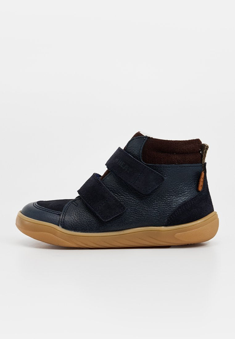 Dunkelblauer Leder-Hochschuh mit zwei Klettverschlüssen und braunen Wildledereinsätzen; Gummisohle mit strukturiertem Profil für besseren Halt.