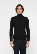 Schwarzer Pullover mit Reißverschluss am Kragen und langen Ärmeln, aus glattem Stoff gefertigt. Verfügt über einen hohen Kragen und minimale Details. Getragen mit dunkler Hose.