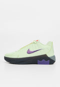 Hellgrüner Nike-Sneaker mit lila Swoosh-Logo, schwarzer Sohle mit lila Akzent, niedrigem Design und Schnürverschluss.