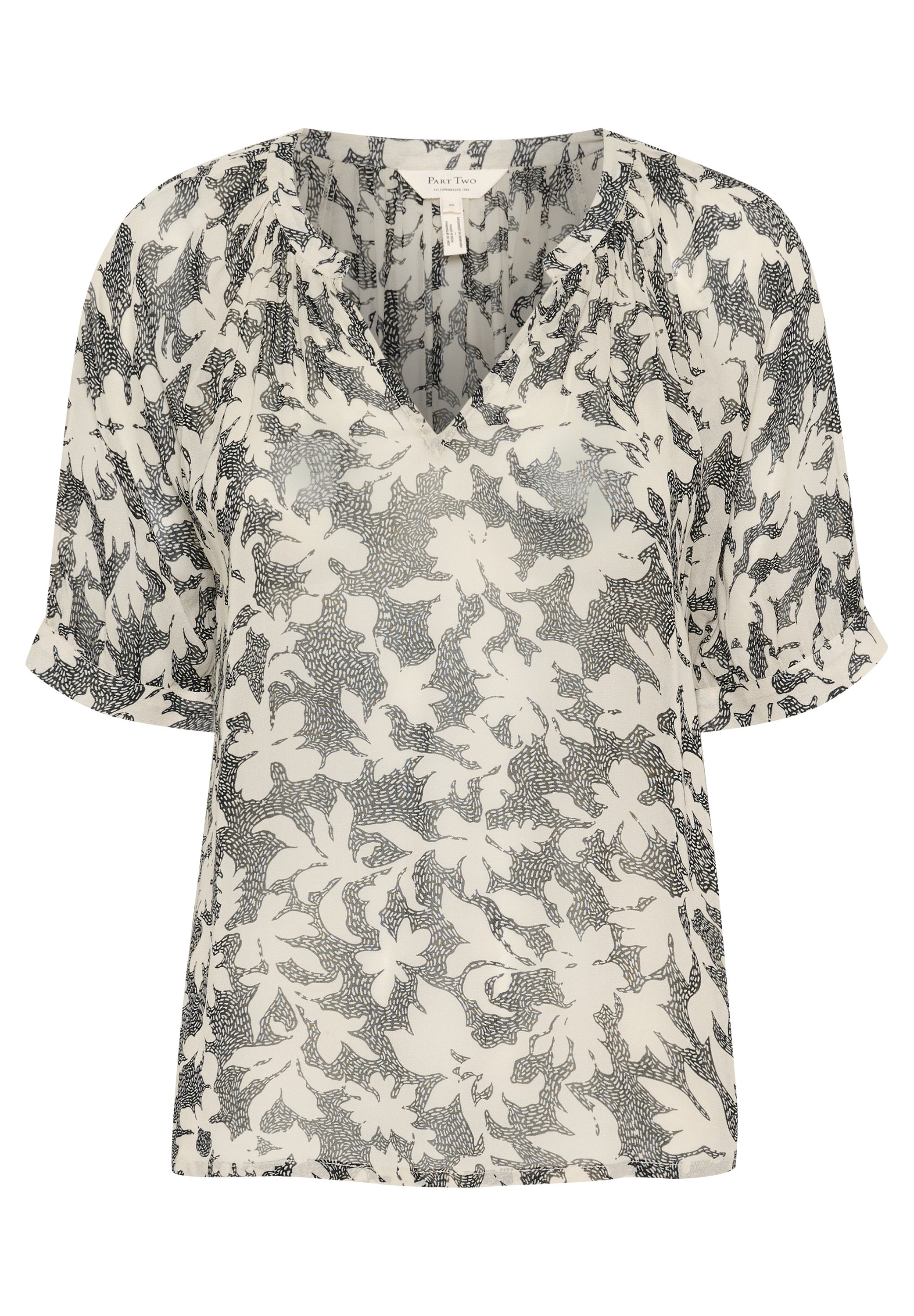 Leichte, durchscheinende Bluse in Creme mit schwarzem Blumenmuster. Verfügt über einen V-Ausschnitt und kurze Ärmel, aus weichem, fließendem Stoff.