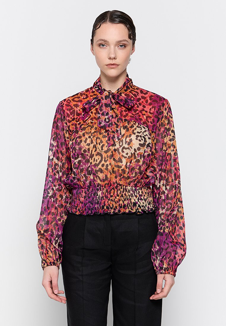 Bunt gemusterte Bluse im Leopardenstil mit langen Ärmeln, gerafftem Bund und Schleifendetail am Hals. Durchscheinender Stoff mit lebhaften Rosa-, Orange- und Purpurtönen.