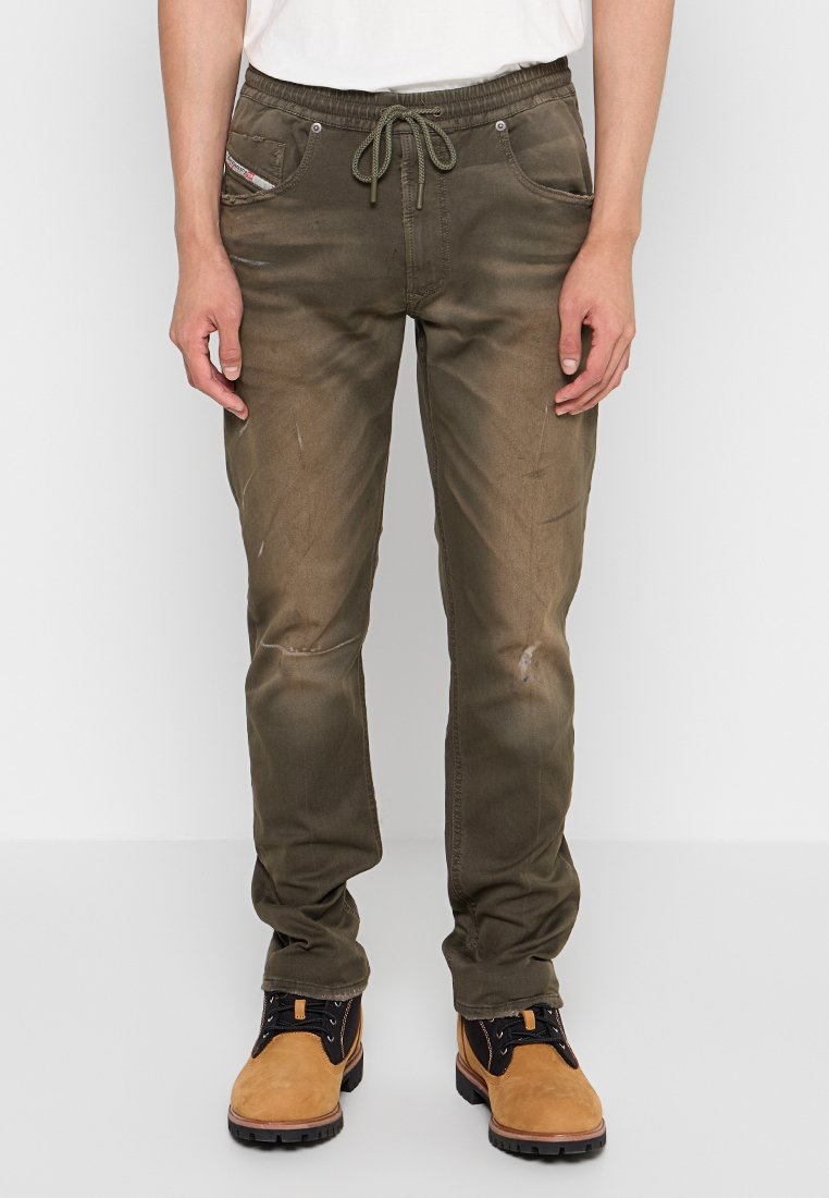 Olivgrüne Hose aus Baumwollmischung mit Kordelzugbund, zwei Fronttaschen und einem leicht abgenutzten Finish.