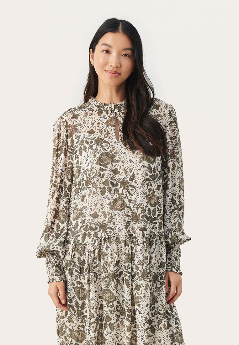 Blumenmuster Kleid aus leichtem, durchsichtigem Stoff mit langen Ärmeln, einem Schlüsselloch-Ausschnitt und einem gerafften Saumvolant. Erdige Farbpalette.