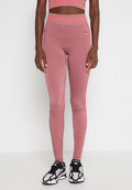 Hochtaillierte pinke Leggings mit geripptem Muster und neonfarbenen Akzenten, kombiniert mit schwarz-weißen Sportschuhen.