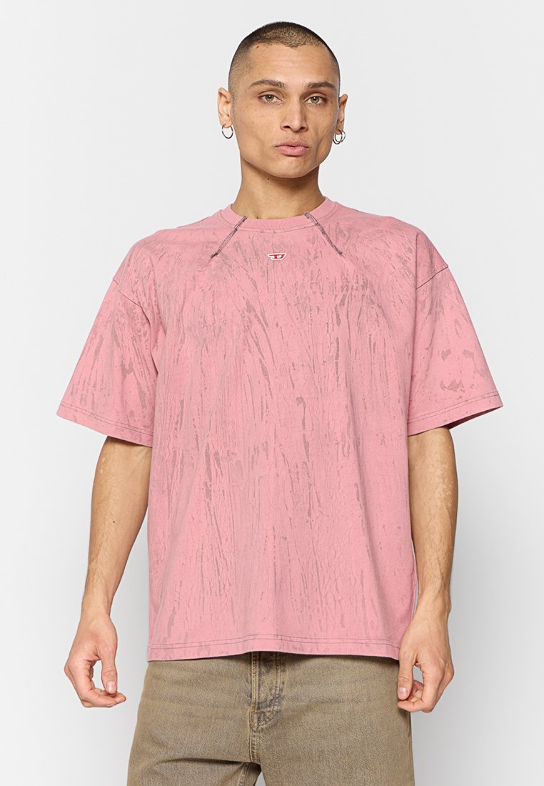 Rosa übergroßes T-Shirt mit einer strukturierten, marmorähnlichen Oberfläche. Verfügt über einen Rundhalsausschnitt und kurze Ärmel, mit einem kleinen Logo-Detail in der Nähe des Kragens.