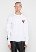 Junger Mann mit kurzen Haaren, der ein weißes Langarmshirt mit schwarzem und rotem "DSL 55"-Logo auf der Brust und Text am rechten Ärmel trägt.