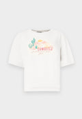 Weißes Baumwoll-T-Shirt mit kurzen Ärmeln, das ein buntes Wüstenmotiv und den Text "COWGIRLS wollen einfach Spaß haben" in Pink und Grün zeigt.