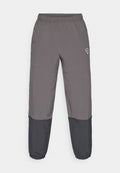 Graue Sporthose mit elastischem Bund, zwei Seitentaschen und schwarzen unteren Einsätzen. Hergestellt aus einem leichten Material, mit einem Logo-Detail.