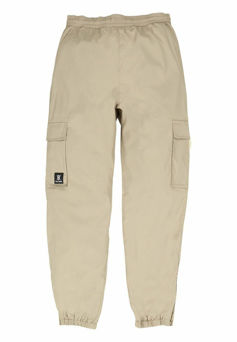 Beige Cargo-Hosen mit einem elastischen Bund, zwei Seiten Taschen und einem strukturierten Stoff. Ein schwarzes Logo-Patch ist auf dem linken Oberschenkel sichtbar.