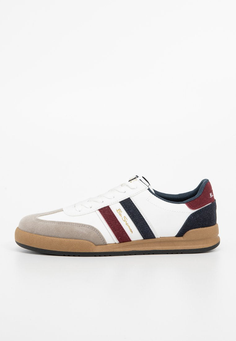Weißer Sneaker mit grauem Wildleder-Zehenteil, blauen und roten gestreiften Akzenten und tanfarbener Gummisohle. Verfügt über ein Schnürdesign und ein goldenes Logo an der Seite.