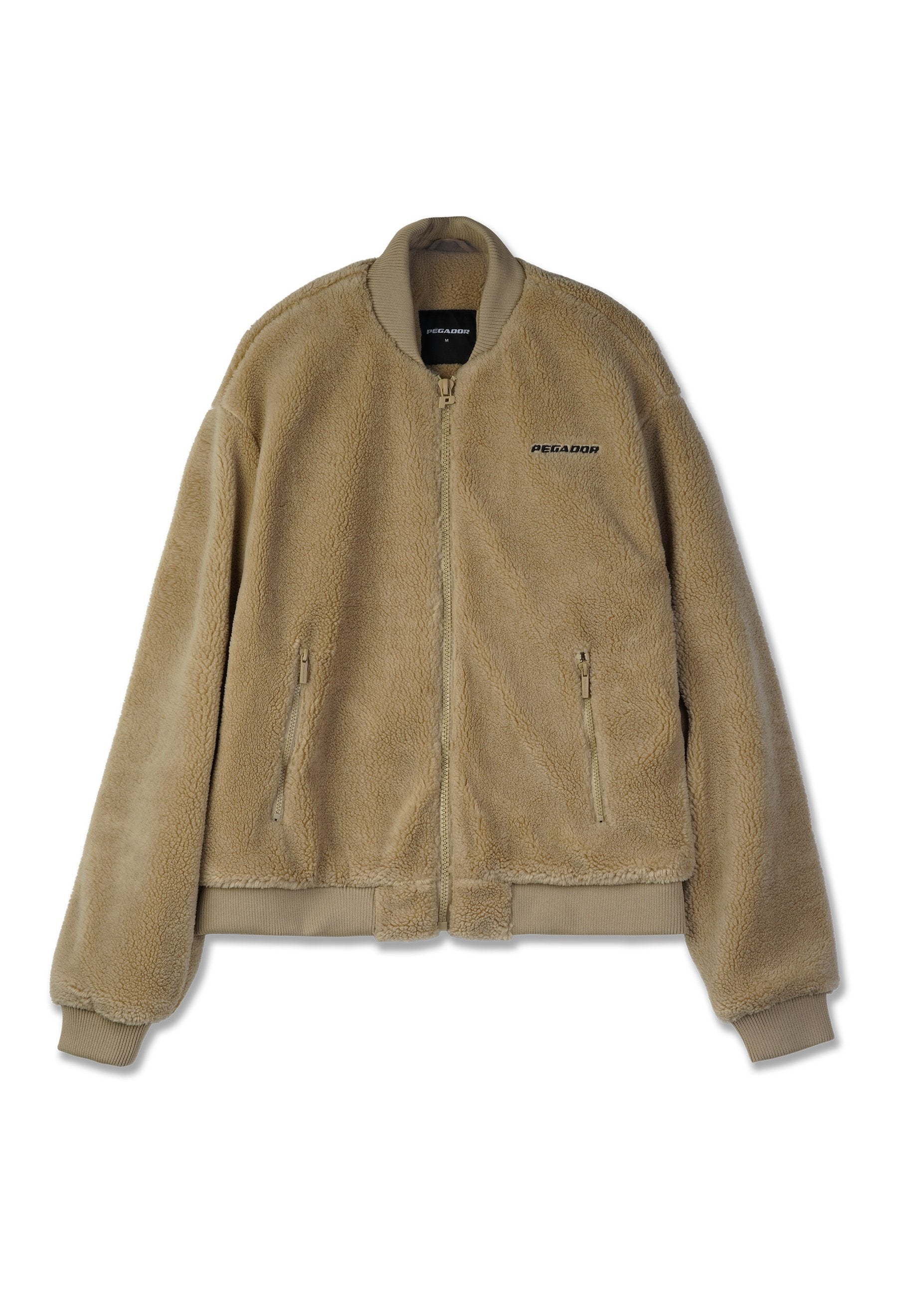 Beige Fleece-Bomberjacke mit Reißverschluss, gerippten Bündchen und Saum. Mit zwei seitlichen Reißverschlusstaschen und "PEGADOR"-Aufdruck auf der Brust.