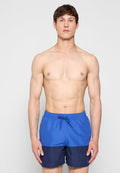 Blaue und marineblaue Badeshorts mit verstellbarem Kordelzugbund und glattem Stoff, mit schlichtem Design ohne Muster oder Akzente.