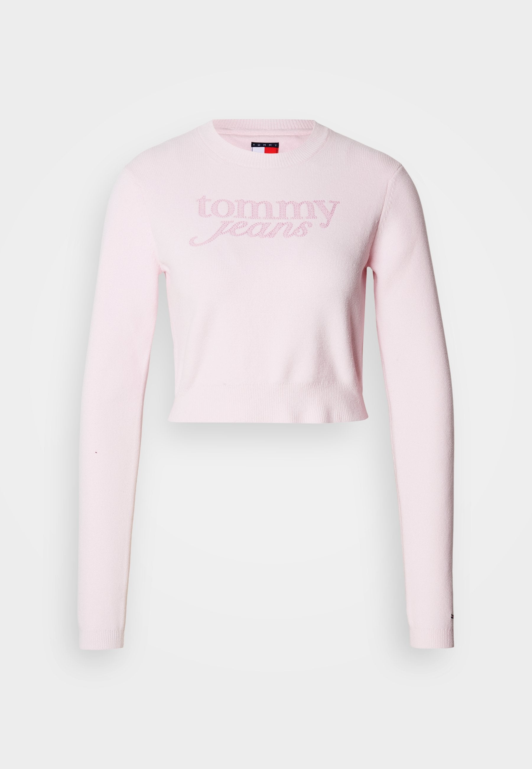 Hellrosa, kurz geschnittener Strickpullover mit langen Ärmeln und rundem Ausschnitt. "Tommy Jeans" Logo auf der Vorderseite geprägt. Weiche Textur.