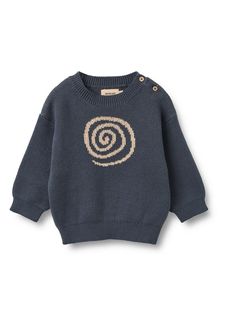 Marineblauer Strickpullover mit einem spiralförmigen Design in Beige in der Mitte. Verfügt über einen breiten Rundhalsausschnitt und zwei Holzknöpfe auf der linken Schulter.