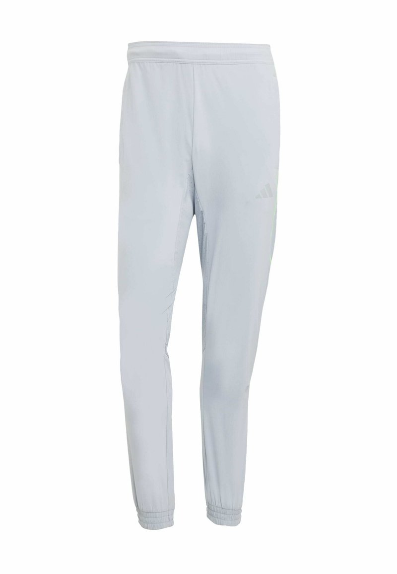 Hellgraue Sporthose mit schmaler Passform, elastischem Bund, gerafften Bündchen und dezenten Logodetails, gefertigt aus feuchtigkeitsableitendem Material.