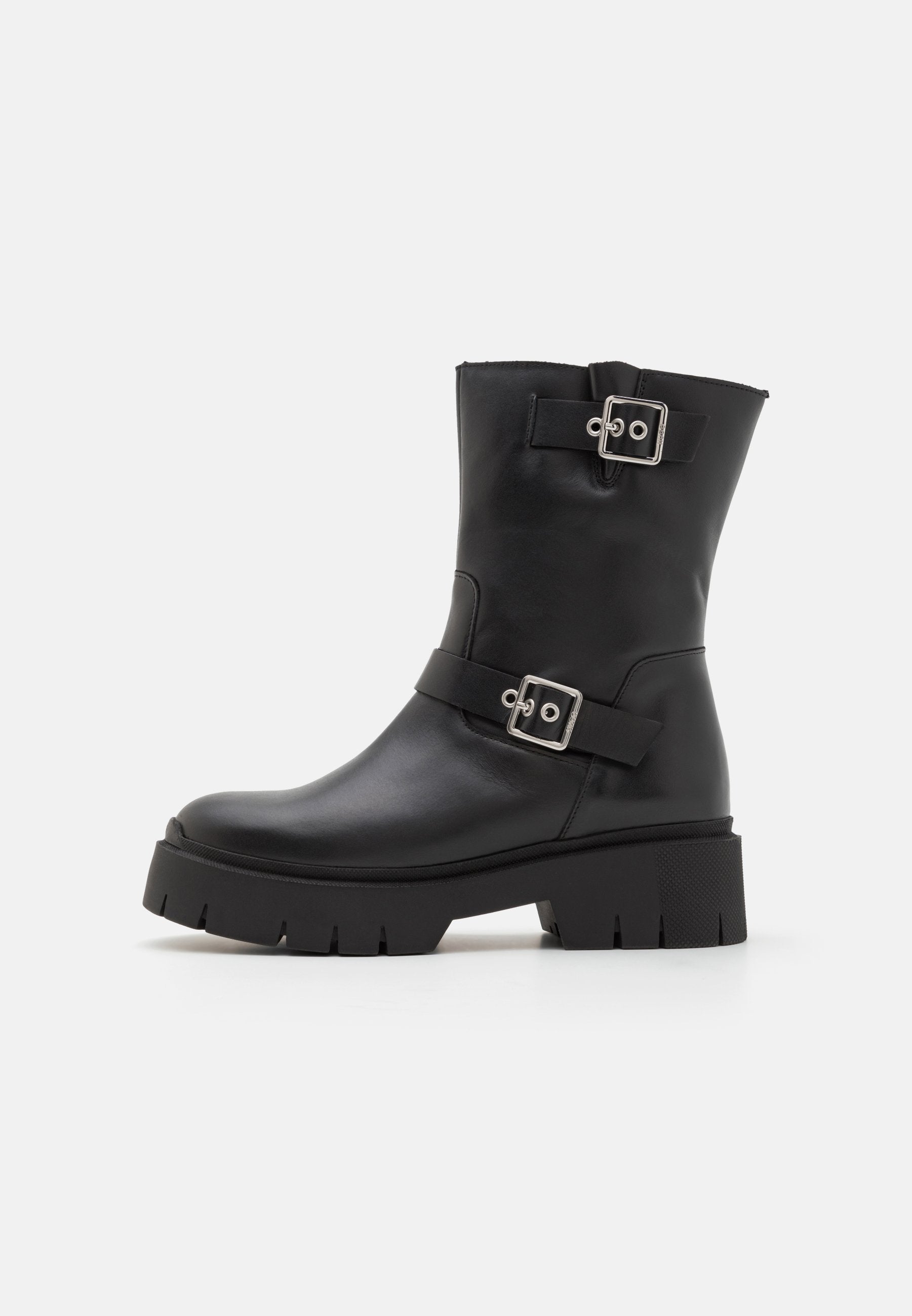 Schwarze Leder-Ankle-Boots mit einer klobigen Sohle, ausgestattet mit zwei Riemen mit silbernen Schnallen. Glatte Oberfläche und robuste Textur an der Sohle.