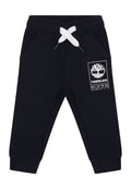 Marineblaue Sweatpants aus Baumwollmischung, mit einem elastischen Bund und weißen Kordeln, seitlichen Taschen und einem Baum-Logo als Grafik.