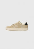 Beige Wildlederschuhe mit weißer Blumenstickerei, runde Zehenform, flache Gummisohle und schwarzem Absatz. Schnürsenkel und gestickte Details an den Seiten.