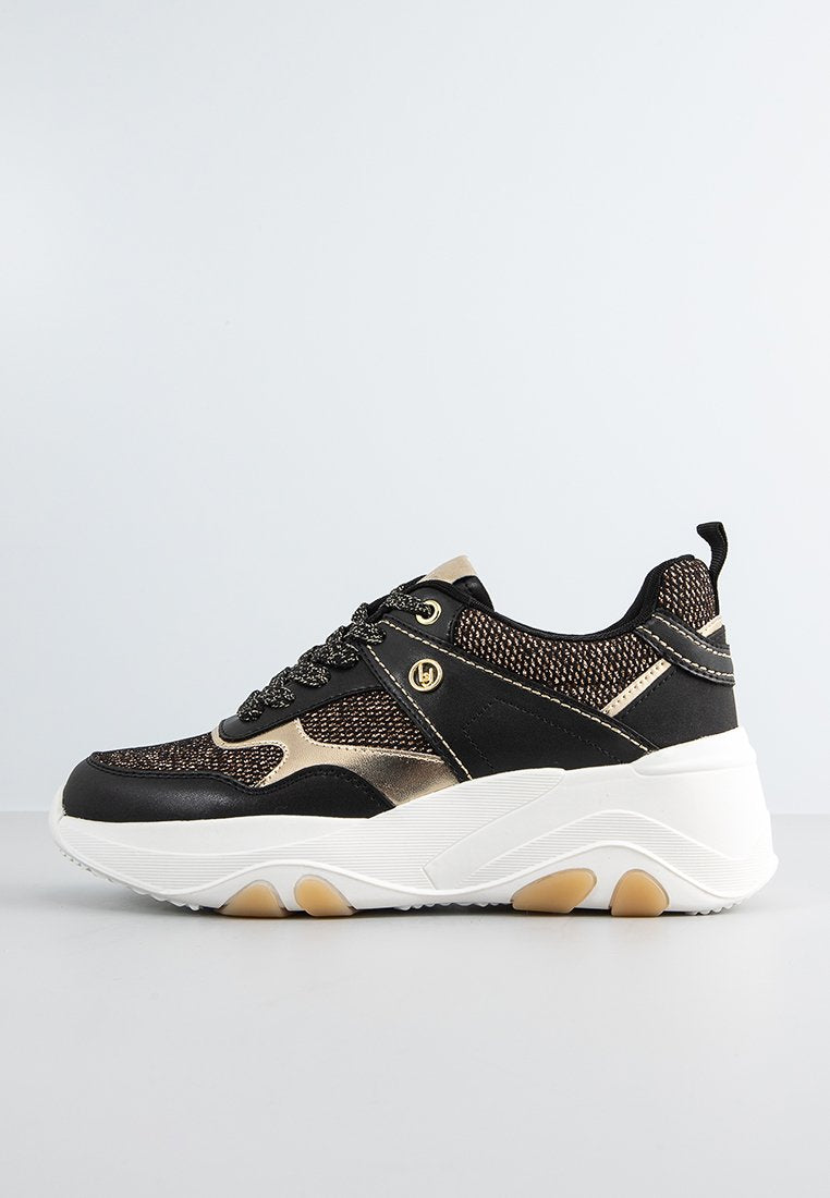 Schwarzer und goldener Sportschuh mit einem Obermaterial aus Mesh, runder Zehenpartie, strukturierten Akzenten und einer dicken weißen Sohle mit goldenen Details.