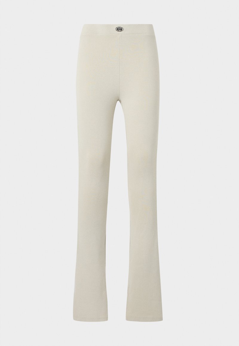 Beige Leggings mit hoher Taille, leicht ausgestelltem Beinabschluss und kleinem, rundem Logo in der Mitte des Taillenbands.